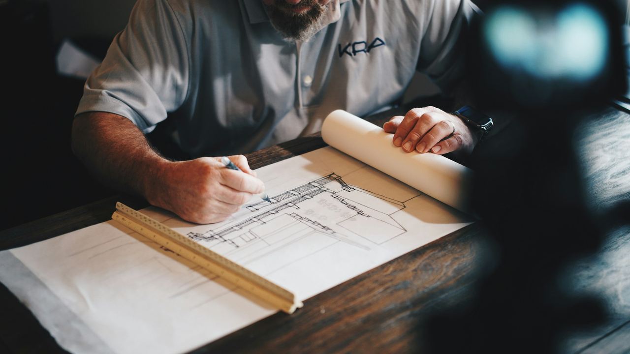 Project team marking up architectural drawings on a work table